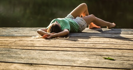 beautiful girl lies on a wooden pier,a dream holiday natureの写真素材