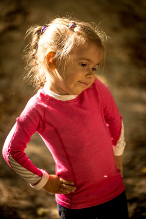 beautiful little girl in the forest beautiful rays of the sun in the background, the emotions of a...