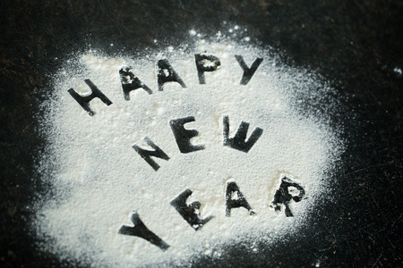 New year 2017 inscription of flour on the table, cut out the letters with the broken bread, and rocking sieveの写真素材