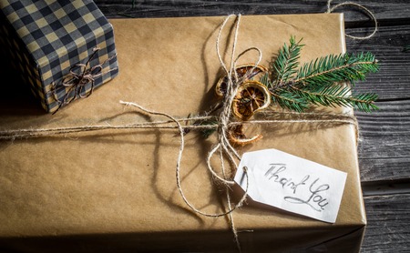 Packed box, beautifully wrapped gift on a wooden background with the words thank you, holiday conceptの写真素材