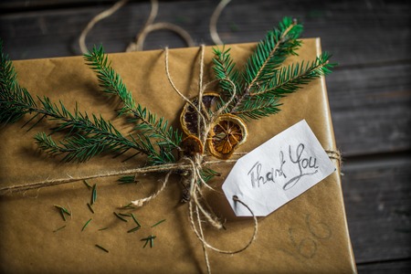 Packed box, beautifully wrapped gift on a wooden background with the words thank you, holiday conceptの写真素材