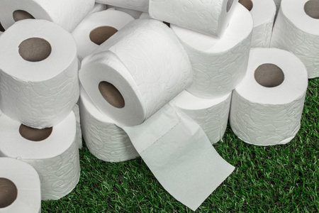 White toilet paper nicely folded on the green grass,the concept of hygiene and cleanliness