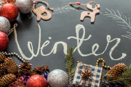 Chalk inscription winter on black chalkboard with Christmas holiday decor, toys ,holidaysの写真素材