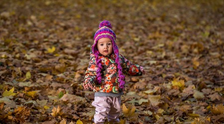 happy little girl in the autumn forest, autumn conceptの写真素材