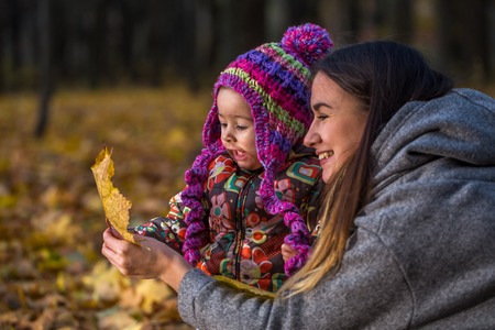 happy seed in autumn forest, a small child with my mother, autumn conceptの写真素材