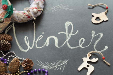 Chalk inscription winter on black chalkboard with Christmas holiday decor, toys ,holidaysの写真素材