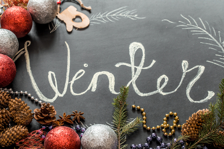 Chalk inscription winter on black chalkboard with Christmas holiday decor, toys ,holidaysの写真素材