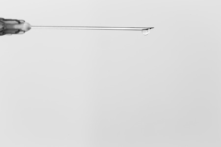 White medical syringe with a drop , isolated on white background, concept of medicineの写真素材