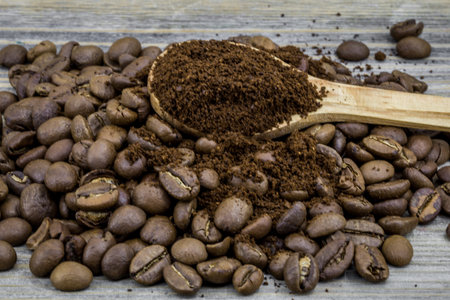 fragrant coffee beans in a beautiful wooden spoon on wooden backgroundの写真素材