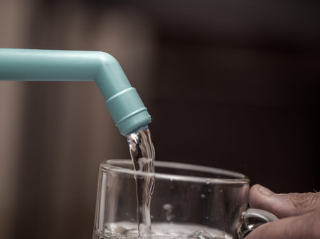 Water filter is poured into a transparent glass closeup