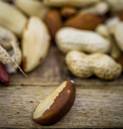 Different mix of nuts closeup on wooden background