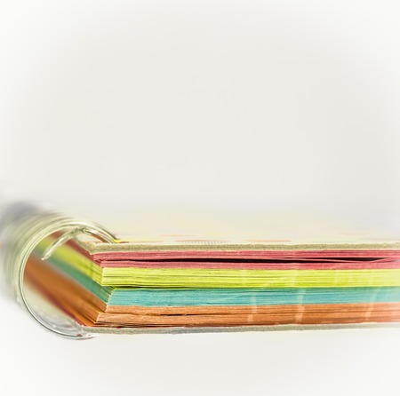 colored notebook with a spring on white background, paper with horizontal stripes, closeupの写真素材