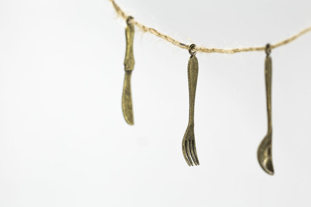 vintage decorative small Cutlery hanging on a rope isolated on white backgroundの写真素材