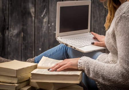 girl sitting on the floor surrounded by many white books and a large candle