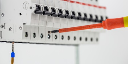 electric machines, switches, isolated on white background, close-up, connect marker cable to a device with a red screwdriverの写真素材