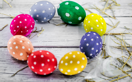 Beautiful colorful Easter composition with eggs on a white wooden backgroundの写真素材