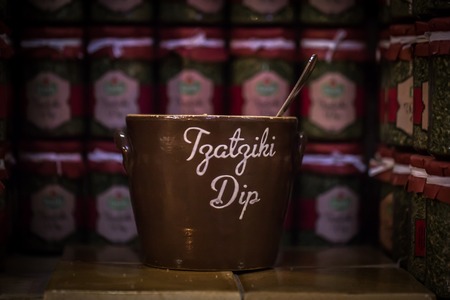 large brown Cup stands on a wooden table,lots of little jars in the backgroundの写真素材