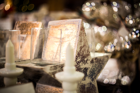 porcelain white candle holder with white candle is a little on the background lightsの写真素材