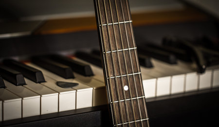 musical instruments piano keys and acoustic guitar closeup, concept, musical composition and...