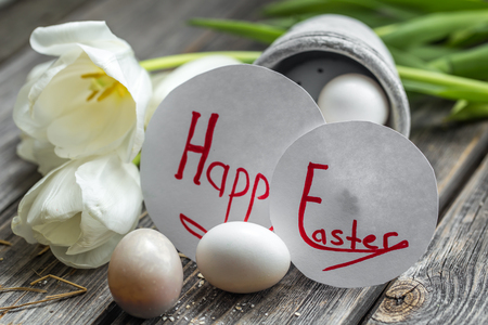 Easter eggs and white tulips on wooden background , holiday conceptの写真素材