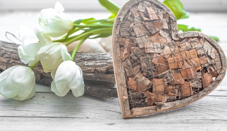 White tulips and a wooden heart on wooden backgroundの写真素材