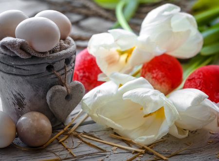 White tulips with pot and red Easter eggs on wooden background ,holiday concept