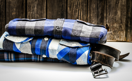 folded men's shirt in the box and the belt with jeans on wooden background ,concept of style and fashionの写真素材