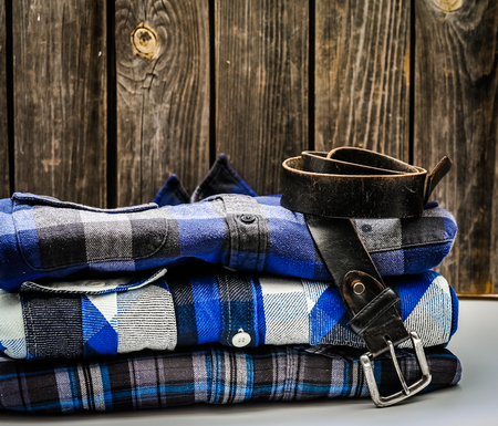 folded men's shirt in the box and the belt with jeans on wooden background ,concept of style and fashionの写真素材