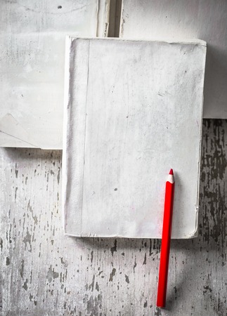 the white book on wooden background with pencils closeup with place for text, concept of knowledge and informationの写真素材