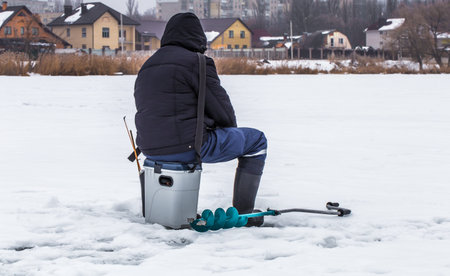 A fisherman on the ice with equipment for winter fishing