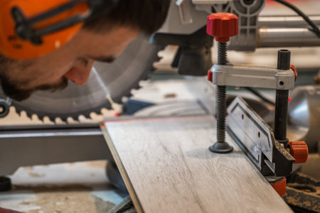 a man working with boards and electric saw ,close-up , concept building and repair