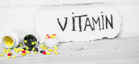 Pills vitamins different colors,with the inscription of vitamin on white background ,concept of healthの写真素材