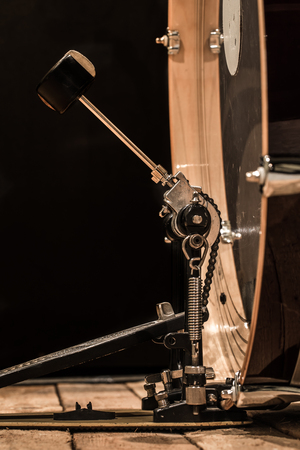 percussion instrument, bass drum with pedal on wooden boards with a black background, the music conceptの写真素材