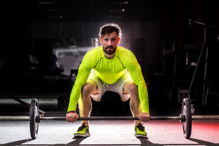 Sports man raises the barの写真素材