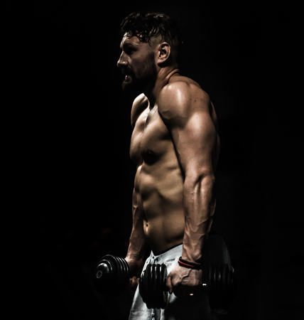 Muscular sports man is engaged in training cross fit in the gym ,the concept of sportの写真素材