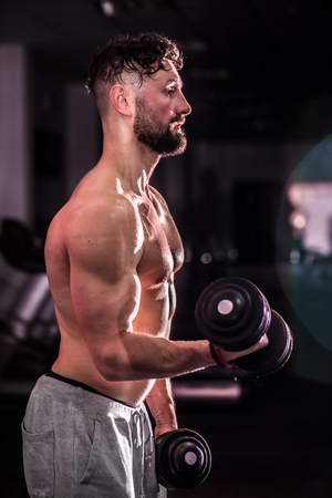 Muscular sports man is engaged in training cross fit in the gym ,the concept of sportの写真素材