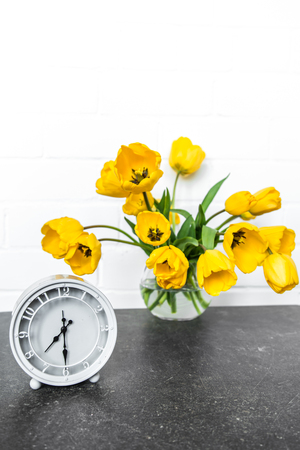 bouquet of yellow tulips and a retro clockの写真素材
