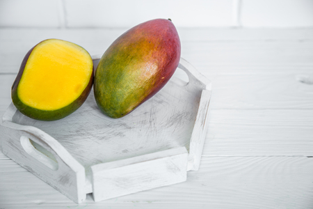 Aromatic ripe Mango on white wooden background ,concept of healthy food and exotic fruitsの写真素材