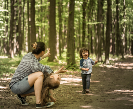 a young Mother with young daughters walk in the woods,the concept of family relations,mother's dayの写真素材