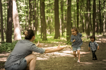 a young Mother with young daughters walk in the woods,the concept of family relations,mother's dayの写真素材