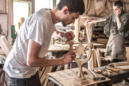 male carpenter working with a wood product, hand tools, close up
