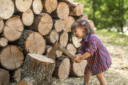 A little girl chopping wood