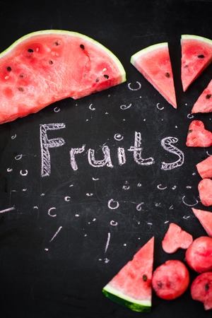 Beautiful ripe Watermelon on a black background with the word fruits,the concept of detox food and nutritionの写真素材