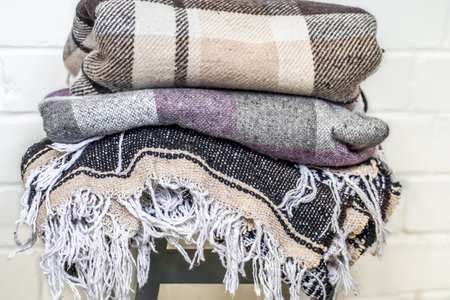 warm cozy blankets stacked on a chair,the concept of warmth and comfortの写真素材