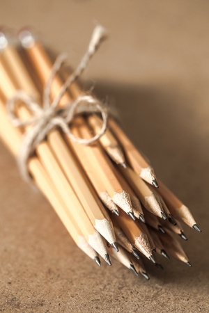 a stack of graphite pencils tied with rope on wooden background ,closeupの写真素材