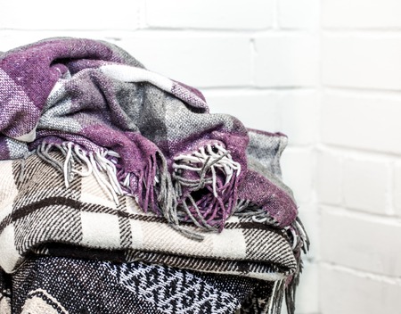 warm cozy blankets stacked on a chair,the concept of warmth and comfortの写真素材