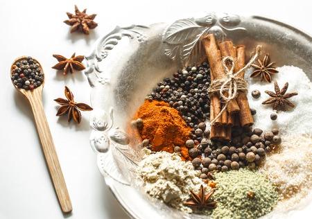 A variety of Oriental spices on a beautiful plate,isolated on white background, concept of spicy food and spicesの写真素材