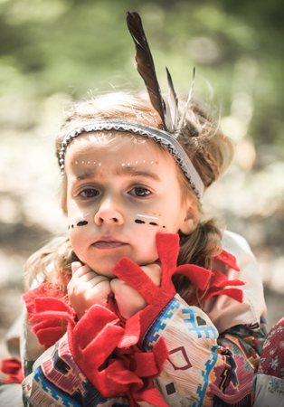 portrait of little cute girl in costume of American Indians ,the concept of children and childhoodの写真素材