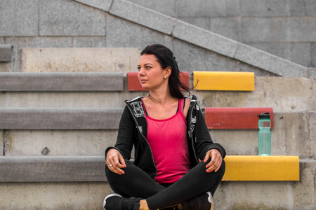 Sports fitness girl sitting on the stairs, the concept of fitness and sports healthy lifestyleの写真素材