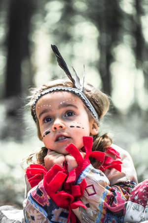 portrait of little cute girl in costume of American Indians ,the concept of children and childhoodの写真素材